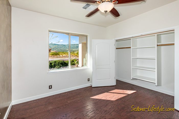Guest Bedroom 3 with light and closet organizer at 2835 S. Quail Canyon Rd, Cottonwood AZ 86326 - For Sale - Call Sheri Sperry for all your real estate needs at 928.274.7355